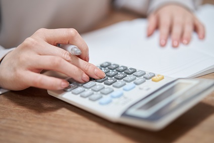 kobieta liczy koszty na kalkulatorze